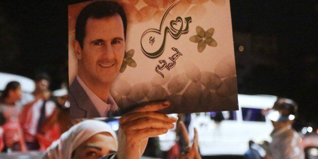A woman holds a picture of re-elected Syrian President Bashar al-Assad as she celebrates in Damascus after he was announced as the winner of the country's presidential elections on June 4, 2014. Assad has been re-elected Syria's president with 88.7 percent of the vote after a poll labelled a farce by rebels fighting to overthrow him, whose outcome was never in doubt. AFP PHOTO/JOSEPH EID (Photo credit should read JOSEPH EID/AFP/Getty Images)
