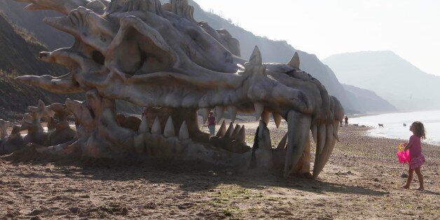 EDITORIAL USE ONLY Pantha Bradbury, three, stands in front of a 39 feet-wide dragon skull, which has been created to celebrate the launch of HBOÕs Game of Thrones Season 3 on the television and movie service, blinkbox, on Charmouth beach on the Jurassic coast in Lyme Regis, Dorset.