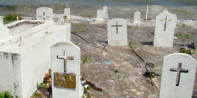 Marshalls-environment-climate-warming, by Giff JohnsonPicture taken in December 2008 shows a cemetery on the shoreline in Majuro Atoll being flooded from high tides and ocean surges. The low-lying Marshall Islands, a Pacific atoll chain that rises barely a metre above sea level, has announced plans for a wall to hold back rising sea levels. AFP PHOTO (Photo credit should read GIFF JOHNSON/AFP/Getty Images)