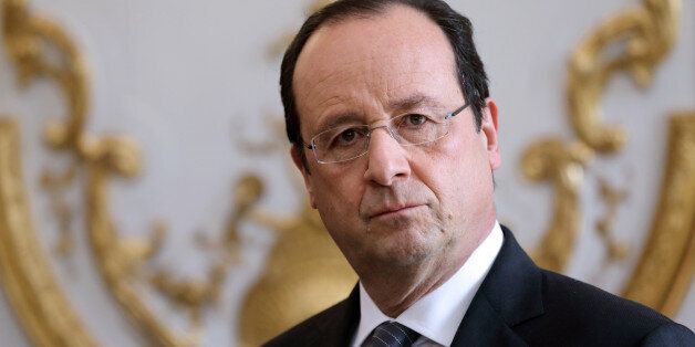 French President Francois Hollande listens to the speech of French Prime Minister during a new year ceremony with members of the government at the Elysee Palace in Paris on January 3, 2014. AFP PHOTO / POOL / PHILIPPE WOJAZER (Photo credit should read PHILIPPE WOJAZER/AFP/Getty Images)