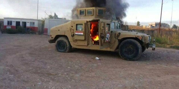 A picture taken with a mobile phone shows an armoured vehicle belonging to Iraqi security forces in flames on June 10, 2014, after hundreds of militants from the Islamic State of Iraq and the Levant (ISIL) launched a major assault on the security forces in Mosul, some 370 kms north from the Iraqi capital Baghdad. Some 500,000 Iraqis have fled their homes in Iraq's second city Mosul after Jihadist militants took control, fearing increased violence, the International Organization for Migration sa