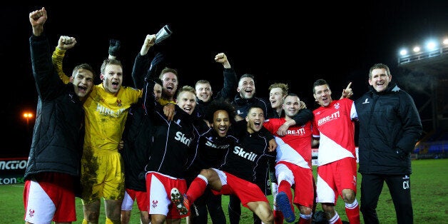 Kidderminster players and staff celebrate their defeat of Peterborough