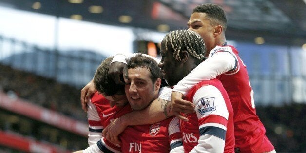 Arsenal's Spanish midfielder Santi Cazorla (C) celebrates scoring the opening goal with teammates during the English Premier League football match between Arsenal and Fulham at the Emirates Stadium in London on January 18, 2014. AFP PHOTO/ADRIAN DENNIS RESTRICTED TO EDITORIAL USE. No use with unauthorized audio, video, data, fixture lists, club/league logos or live services. Online in-match use limited to 45 images, no video emulation. No use in betting, games or single club/league/player publications. (Photo credit should read ADRIAN DENNIS/AFP/Getty Images)