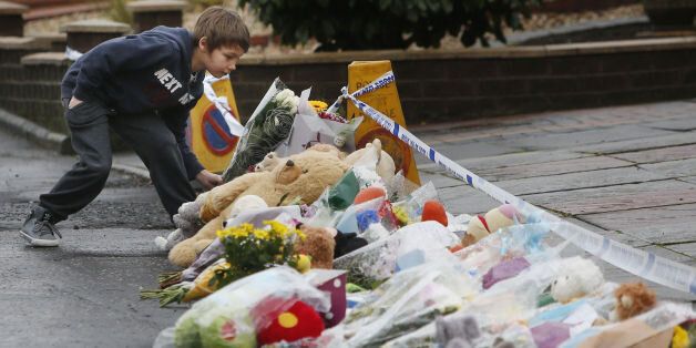 A young boy with floral tributes on Dunvegan Avenue in Kirkcaldy, Scotland: Danny Lawson/PA Wire