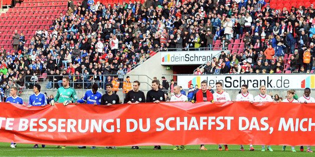 COLOGNE, GERMANY - JANUARY 18: Players of Schalke and Koeln show a banner for Michael Schumacher prior to a test match between 1. FC Koeln and FC Schalke 04 at RheinEnergieStadion on January 18, 2014 in Cologne, Germany. (Photo by Lars Baron/Bongarts/Getty Images)
