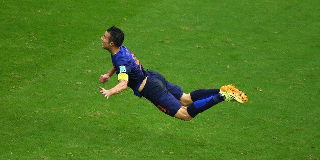 SALVADOR, BRAZIL - JUNE 13: Robin van Persie of the Netherlands scores the team's first goal with a diving header in the first half during the 2014 FIFA World Cup Brazil Group B match between Spain and Netherlands at Arena Fonte Nova on June 13, 2014 in Salvador, Brazil. (Photo by Jeff Gross/Getty Images)