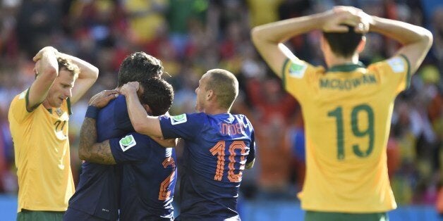 Netherlands' forward Memphis Depay (C) is congratulated by teammates after scoring during a Group B football match between Australia and the Netherlands at the Beira-Rio Stadium in Porto Alegre during the 2014 FIFA World Cup on June 18, 2014. AFP PHOTO / JUAN BARRETO (Photo credit should read JUAN BARRETO/AFP/Getty Images)