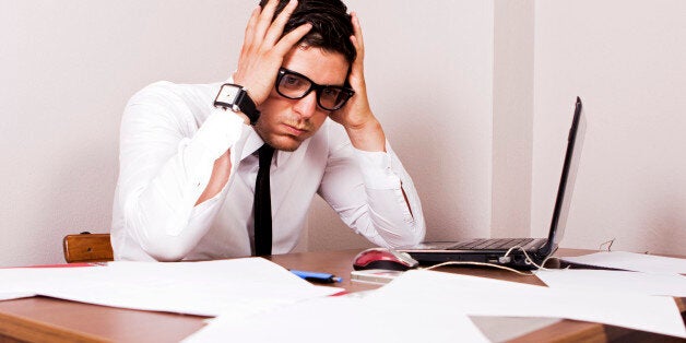 Young businessman holding his head and seems so worried