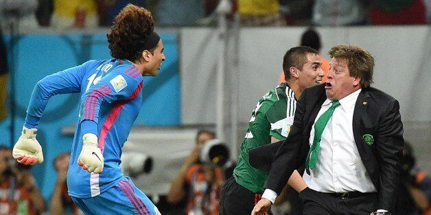 Mexico's goalkeeper Guillermo Ochoa (L) and Mexico's coach Miguel Herrera (R) celebrate a goal by their team during a Group A football match between Croatia and Mexico at the Pernambuco Arena in Recife during the 2014 FIFA World Cup on June 23, 2014. AFP PHOTO / DIMITAR DILKOFF (Photo credit should read DIMITAR DILKOFF/AFP/Getty Images)