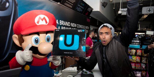 Izzy Rahman, 25, from London is the first to buy the Nintendo Wii U from the HMV store on London's Oxford Street, after queuing for six days for the launch.