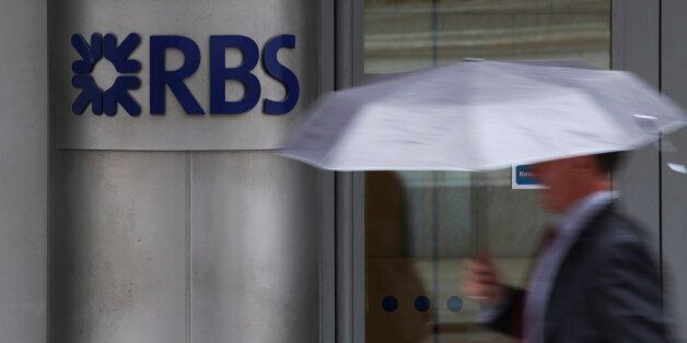 A pedestrian passes a sign outside the headquarters of the Royal Bank of Scotland Group Plc (RBS) in London, U.K., on Wednesday, July 18, 2012. The U.K. financial regulator said it's investigating seven lenders over attempts to manipulate interbank offered rates as lawmakers criticized it for not opening the probe earlier. Photographer: Chris Ratcliffe/Bloomberg via Getty Images