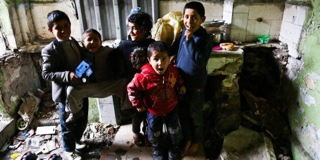 Syrian boys pose on January 27, 2014 in the Kucukpazar district of Istanbul. Syrians fill houses which have been evacuated for urban development projects. Destitute Syrian refugees who have fled the war in Syria and camps in Turkey are fighting for their lives in different parts of Istanbul. Refugees who moved into the houses in Kucukpazar neighbourhood near the historic Suleymaniye mosque, are struggling to live without water and heating. Those who moved into houses which were evacuated due to