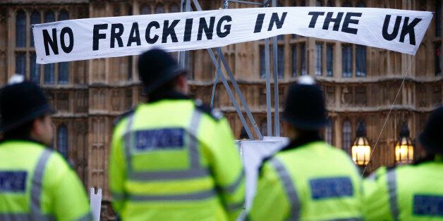 British police secure the area where demonstrators erected a mock fracking rig with a banner reading 'No fracking in the UK' in a protest against hydraulic fracturing for shale gas outside the Houses of Parliament in London on December 1, 2012. The demonstration organised by various groups protested against any expansion into Britain of the pratcice of 'hydraulic fracturing' or 'fracking' for shale gas which the Campaign Against Climate Change group, one of the organisations involved in the acti