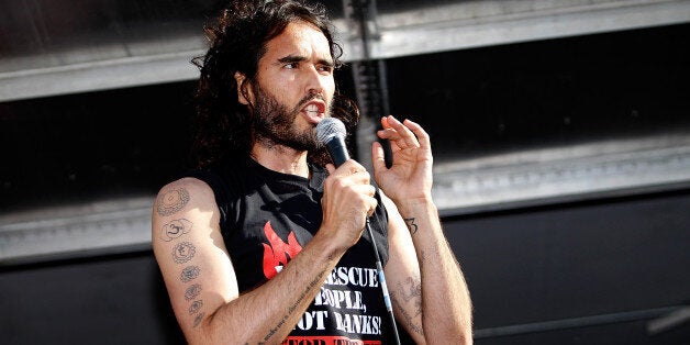 LONDON, ENGLAND - JUNE 21: Comedian Russell Brand speaks to a crowd of thousand of demonstrators that gathered in Parliament Square, on June 21, 2014 in London, England. The crowd marched from Oxford Circus to Parliament Square to voice their opposition to government austerity cuts. (Photo by Mary Turner/Getty Images)