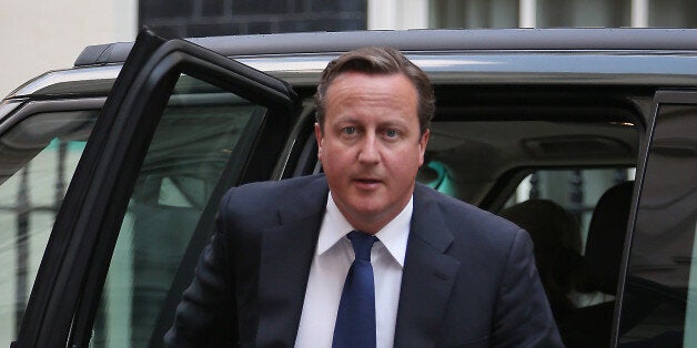 LONDON, ENGLAND - AUGUST 27: Prime Minister David Cameron arrives at 10 Downing Street on August 27, 2013 in London, England. Mr Cameron has returned early from his holiday to deal with the situation in Syria and a possible recall of Parliament.. (Photo by Peter Macdiarmid/Getty Images)