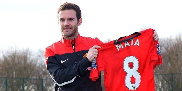 Manchester United's new signing, Spanish midfielder Juan Mata, poses with a team jersey at the club training ground in Manchester, north west England, on January 27, 2014. Manchester United manager David Moyes said on January 26 that the club-record acquisition of Spanish midfielder Juan Mata from Chelsea would be the first of many new signings this year. United completed a move for Mata on Saturday for a fee of 37.1 million GBP (61.2 million USD, 44.8 million euros), eclipsing the 30.75 million