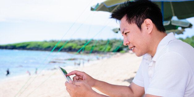 Man on the beach using a smart phone.