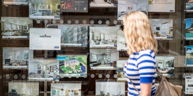 LONDON, ENGLAND - MAY 19: A woman walks past an estate agent's window display on Brompton Road in Knightsbridge on May 19, 2014 in London, England. The governor of the Bank of England, Mark Carney, has given his strongest warning yet about the dangers to Britain's economy posed by the booming housing market saying that the market represented the biggest risk to financial stability and the long-term recovery. (Photo by Rob Stothard/Getty Images)