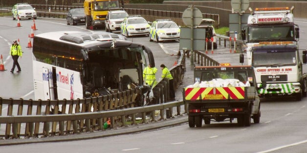 Emergency workers at the scene between junction 25 and 26 eastbound on the M4 in south Wales following a smash involving a lorry, bus and a number of cars at around 9.30am this morning.