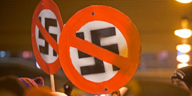 Left-wing demonstrators hold a sign with a crossed out swastika to protest against a far-right march marking the 67th anniversary of the allied bombings during World War II in Dresden, eastern Germany, on February 13, 2013. A massive bombing raid by Allied forces on Dresden beginning on February 13, 1945 sparked a firestorm that destroyed much of the historical centre of the city. AFP PHOTO / ROBERT MICHAEL (Photo credit should read ROBERT MICHAEL/AFP/Getty Images)