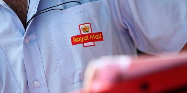 An embroidered logo sits on the shirt pocket of a Royal Mail Group Ltd. postman as he delivers mail in Hornchurch, U.K., on Wednesday, July 10, 2013. The U.K. government will sell a majority stake in Royal Mail Group Ltd., the 360-year-old state postal service, through an initial public offering before the end of March, Business Secretary Vince Cable said. Photographer: Chris Ratcliffe/Bloomberg via Getty Images