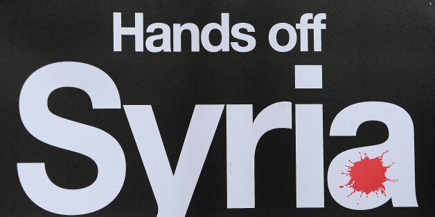 A protestor holds a placard during a protest against military intervention in Syria outside the American embassy in central London on September 3, 2013. Former Bosnian war mediator David Owen urged world leaders at this week's G20 summit to break the deadlock over Syria, saying Germany, India, Japan and Brazil could push Russia towards a diplomatic solution. AFP PHOTO / BEN STANSALL (Photo credit should read BEN STANSALL/AFP/Getty Images)