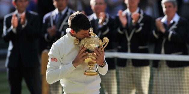 Serbia's Novak Djokovic reacts after losing a point to Switzerland's Roger Federer during their men's singles final match on day thirteen of the 2014 Wimbledon Championships at The All England Tennis Club in Wimbledon, southwest London, on July 6, 2014. AFP PHOTO / CARL COURT - RESTRICTED TO EDITORIAL USE (Photo credit should read CARL COURT/AFP/Getty Images)