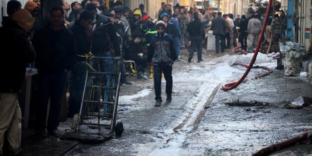 Civilians inspect the site after a parked car bomb went off at a commercial center in Khilani Square in central Baghdad, Iraq, Wednesday, Feb. 5, 2014. Multiple bombings rocked central Baghdad on Wednesday, striking mainly near the heavily fortified Green Zone where key government offices are located and killing at least 16 people, Iraqi officials said. (AP Photo/Karim Kadim)