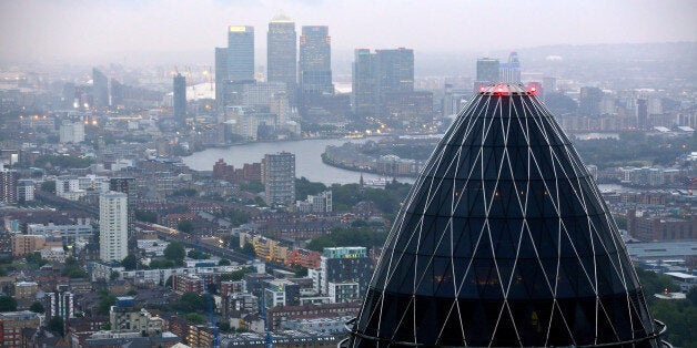 The Swiss Re Insurance building, also known as 'the Gherkin', foreground, and the towers of the Canary Wharf business district are seen against the city skyline in London, U.K. on Thursday, July 12, 2012. Banks being probed for attempting to rig benchmark interest rates could face $6 billion of related litigation costs, analysts at Morgan Stanley estimated. Photographer: Jason Alden/Bloomberg via Getty Images