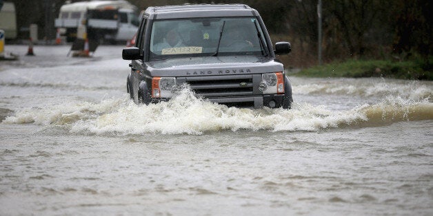 Residents drive through flood water on February 11, 2014 in Chertsey, United Kingdom.