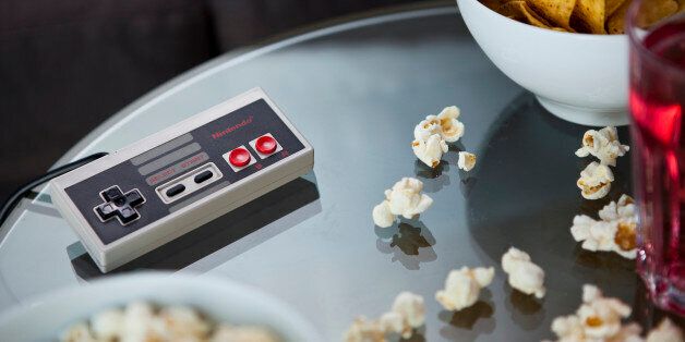 A vintage Nintendo NES controller photographed on a glass table, surrounded by bowls of snacks, taken on July 9, 2013. (Photo by Philip Sowels/Future Publishing via Getty Images)