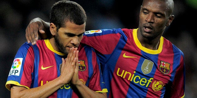 Barcelona's Brazilian defender Daniel Alves (L) is congratuled by his teammate French defender Eric Abidal (R) after scoring during a Spanish League football match against Sevilla at the Camp Nou Stadium in Barcelona , on October 30, 2010. AFP PHOTO / JOSEP LAGO (Photo credit should read JOSEP LAGO/AFP/Getty Images)