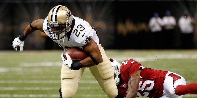 New Orleans Saints' Pierre Thomas avoids a tackle by Rashad Johnson