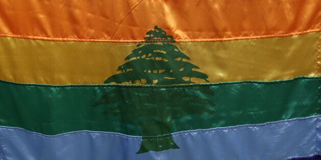 A gay pride flag bearing the cedar tree in the middle of it is carried by a human rights activists during an anti-homophobia rally in Beirut on April 30, 2013. Lebanese homosexuals, human rights activists and members from the NGO Helem (the Arabic acronym of 'Lebanese Protection for Lesbians, Gays, Bisexuals and Transgenders') rallied to condemn the arrest on the weekend of three gay men and one transgender civilian in the town of Dekwaneh east of Beirut at a nightclub who were allegedly verbally and sexually harassed at the municipality headquarters. AFP PHOTO/JOSEPH EID (Photo credit should read JOSEPH EID/AFP/Getty Images)