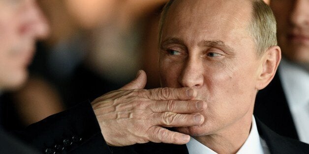 Russian President Vladimir Putin gestures while leaving the BRICS-UNASUR Summit at Itamaraty Palace in Brasilia, Brazil on July 16, 2014. The leaders of Brazil, Russia, India, China and South Africa held talks in the Brazilian capital with counterparts from Argentina, Chile, Colombia, Ecuador, Venezuela and other Latin American nations. AFP PHOTO/EVARISTO SA (Photo credit should read EVARISTO SA/AFP/Getty Images)