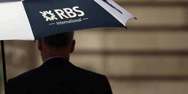 A pedestrian carries a Royal Bank of Scotland Group Plc (RBS) branded umbrella in London, U.K., on Friday, Nov. 1, 2013. Royal Bank of Scotland Group expects to post a 'substantial' full-year loss after transferring 38.3 billion pounds ($61 billion) of its worst loans to an internal bad bank under government pressure. Photographer: Chris Ratcliffe/Bloomberg via Getty Images