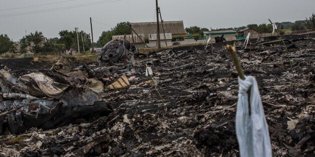 GRABOVKA, UKRAINE - JULY 18: Debris from an Malaysia Airlines plane crash, including a white ribbon tied to a stick which indicates the presence of human remains, lies in a field on July 18, 2014 in Grabovka, Ukraine. Malaysia Airlines flight MH17 travelling from Amsterdam to Kuala Lumpur has crashed on the Ukraine/Russia border near the town of Shaktersk. The Boeing 777 was carrying 280 passengers and 15 crew members. (Photo by Brendan Hoffman/Getty Images)