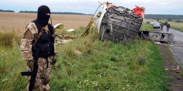 An armed pro-Russia militant stands guard at the site of the crash of a Malaysian airliner carrying 298 people from Amsterdam to Kuala Lumpur in Grabove, in rebel-held east Ukraine, on July 18, 2014. Pro-Russian separatists in the region and officials in Kiev blamed each other for the crash, after the plane was apparently hit by a surface-to-air missile. Members of the UN Security Council demanded a full, independent investigation into the apparent shooting down of a Malaysia Airlines jet over U