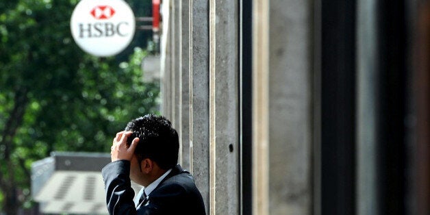 A member of staff outside a HSBC branch on Victoria Street, London as the banking giant today warned it will cut up to 30,000 posts by 2013 as the jobs cull among the world's big banks gathers pace.