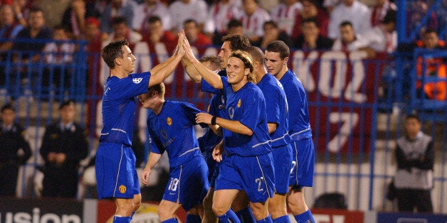 ATHENS, GREECE - OCTOBER 23: Phil Neville and Diego Forlan celebrate with Laurent Blanc after his opening goal in the UEFA Champions League match between Olympiakos v Manchester United on October 22, 2002. (Photo by Matthew Peters/Manchester United via Getty Images)