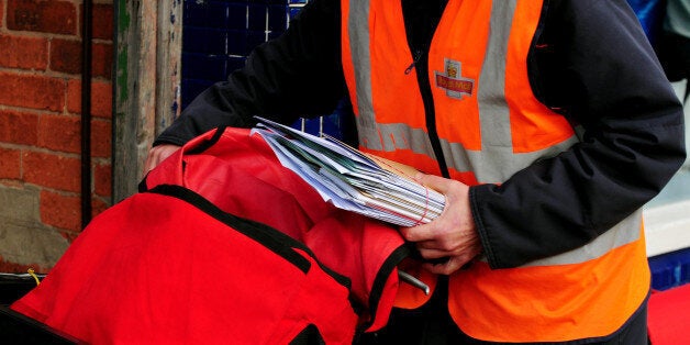 File photo dated 23/10/09 of a postal worker delivering mail in Beeston, Nottingham. Royal Mail has called for a review of the direct delivery market amid the fresh warnings it poses to the universal delivery market.