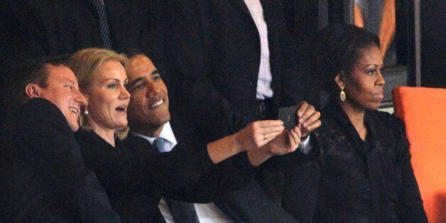 -- AFP PICTURES OF THE YEAR 2013 --US President Barack Obama (R) and British Prime Minister David Cameron pose for a selfie picture with Denmark's Prime Minister Helle Thorning Schmidt (C) next to US First Lady Michelle Obama (R) during the memorial service of South African former president Nelson Mandela at the FNB Stadium (Soccer City) in Johannesburg on December 10, 2013. Mandela, the revered icon of the anti-apartheid struggle in South Africa and one of the towering political figures of the