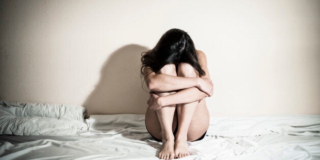 Stock image of woman sitting on bed