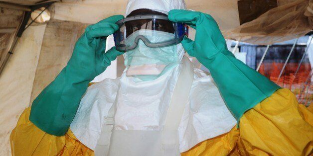 A picture taken on June 28, 2014 shows a member of Doctors Without Borders (MSF) putting on protective gear at the isolation ward of the Donka Hospital in Conakry, where people infected with the Ebola virus are being treated. The World Health Organization has warned that Ebola could spread beyond hard-hit Guinea, Liberia and Sierra Leone to neighbouring nations, but insisted that travel bans were not the answer. To date, there have been 635 cases of haemorrhagic fever in Guinea, Liberia and Sier