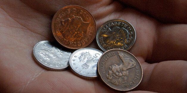 View of a woman's hand holding 17p in British Sterling; the amount which the minimum wage is to increase by.