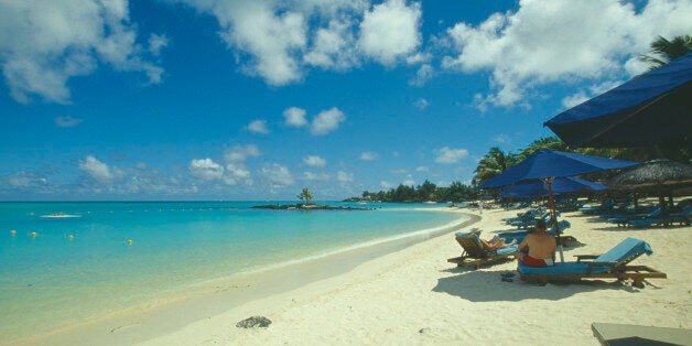 MAURITIUS Grand Bay The beach at the Mauritius Hotel. People on sun loungers and umbrellas.