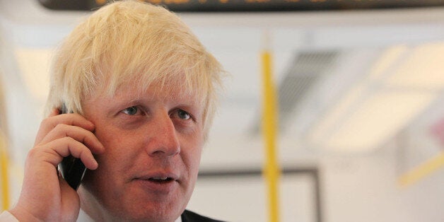 London Mayor Boris Johnson talks on the phone inside the first new air-conditioned train, as by 2015 40\% of tube trains will be air-conditioned.