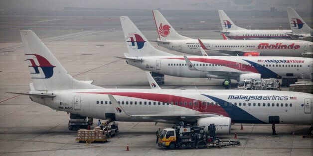 Aircraft operated by Malaysian Airline System Bhd. (MAS) and PT Lion Mentari Airlines (Lion Air) stand shrouded in haze at Kuala Lumpur International Airport (KLIA) in Sepang, Malaysia, on Friday, March 14, 2014. Indian forces expanded the search for missing Malaysian Airlines Flight 370 to the Bay of Bengal after evidence mounted the plane with 239 people on board may have flown long after controllers lost contact with it a week ago. Photographer: Charles Pertwee/Bloomberg via Getty Images