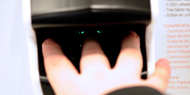 A man tests an optical fingerprints reader displayed at a stand of the Expoprotection, an International Exhibition for risk protection and management, on December 7, 2012. AFP PHOTO / LIONEL BONAVENTURE (Photo credit should read LIONEL BONAVENTURE/AFP/Getty Images)