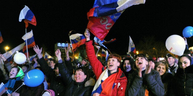 Pro-Russian Crimeans celebrate in Sevastopol on March 16, 2014 after partial showed that about 95.5 percent of voters in Ukraine's Crimea region supported union with Russia. Crimeans voted overwhelmingly to join former political master Russia as tensions soared in the east of the splintered ex-Soviet nation amid the worst East-West crisis since the Cold War. AFP PHOTO/ VIKTOR DRACHEV (Photo credit should read VIKTOR DRACHEV/AFP/Getty Images)